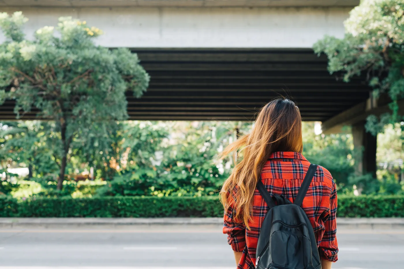 An international student with a backpack looking ahead on a campus street