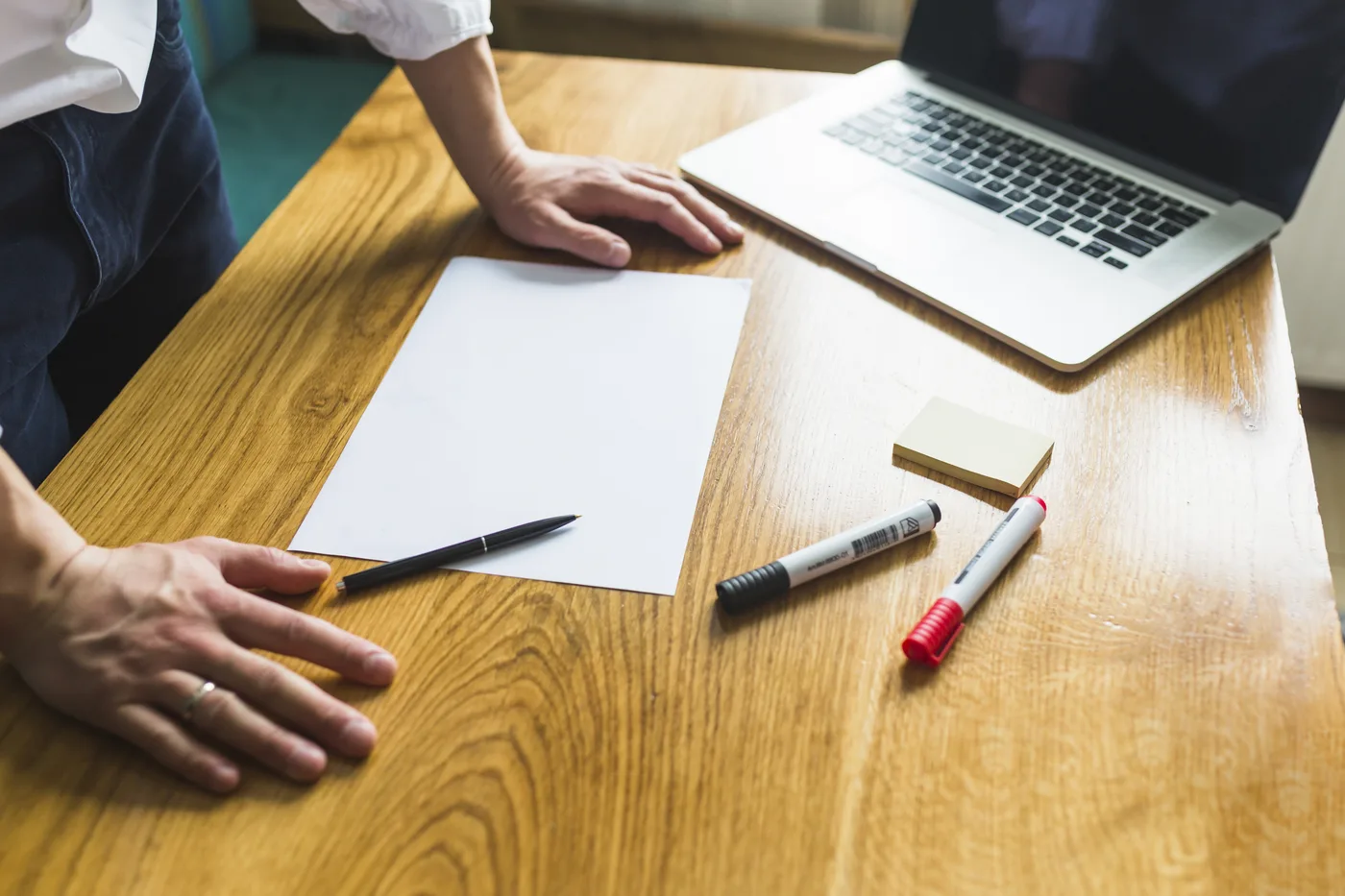 A desk with a blank sheet of paper, pen and laptop, ready for careful preparation