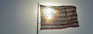 American flag with sunlight peeking through