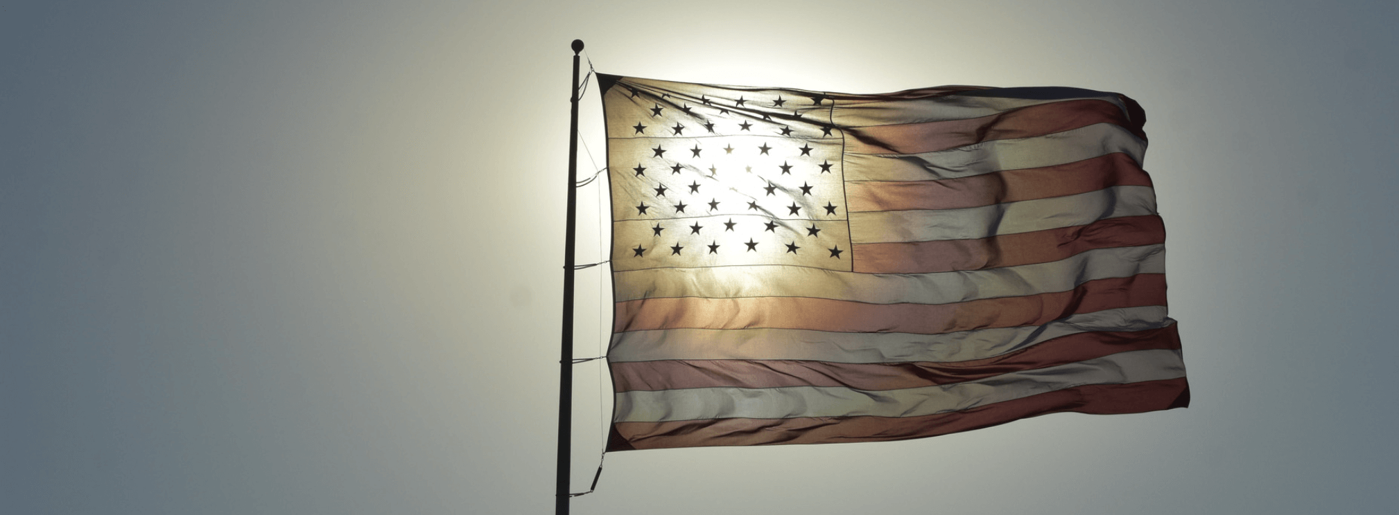 American flag with sunlight peeking through