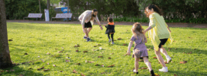 a family playing on the green grass field